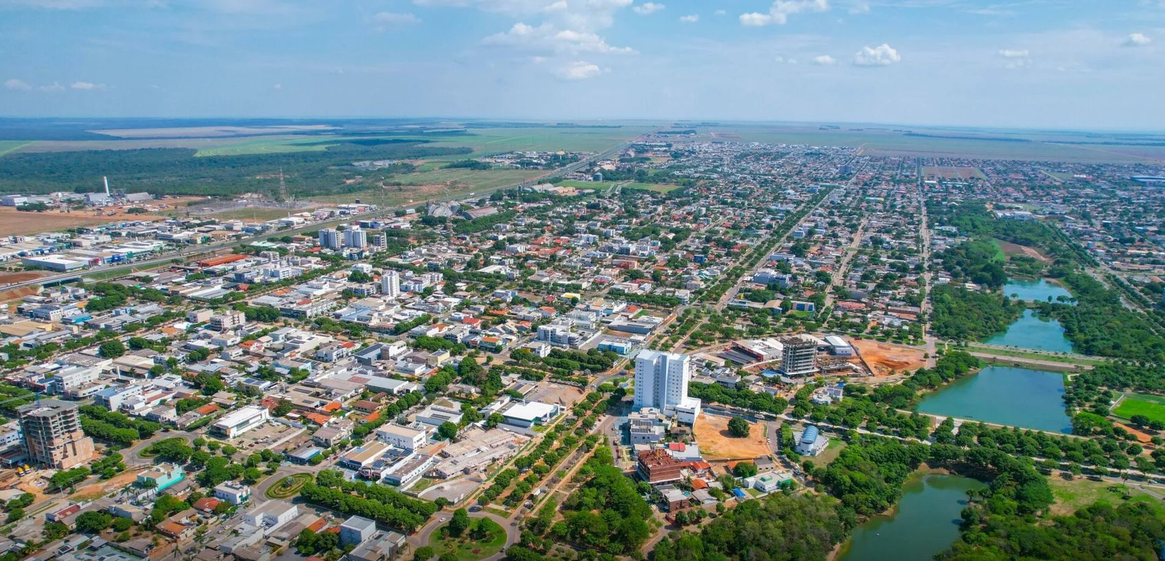 Vista aérea de Nova Mutum, com a avenida central e as lagoas
